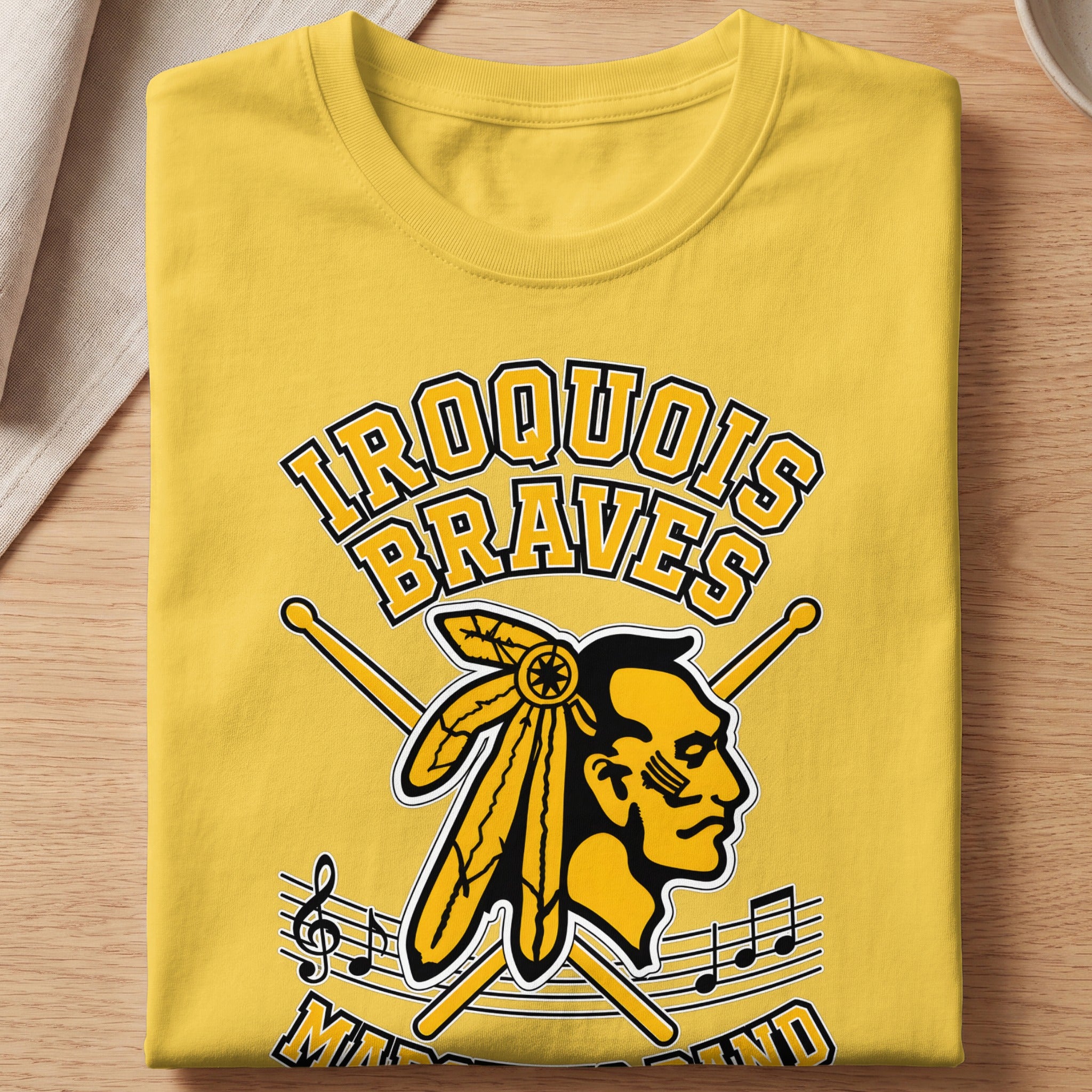 Iroquois Braves marching band graphic on a yellow t-shirt with drumsticks and music notes.