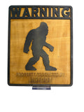 RJ Custom Works wooden sign with black Bigfoot silhouette and "WARNING PROPERTY PROTECTED BY BIGFOOT" text.