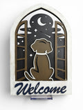 RJ Custom Works wooden welcome sign with a silhouette of a dog looking out a window at the night sky.
